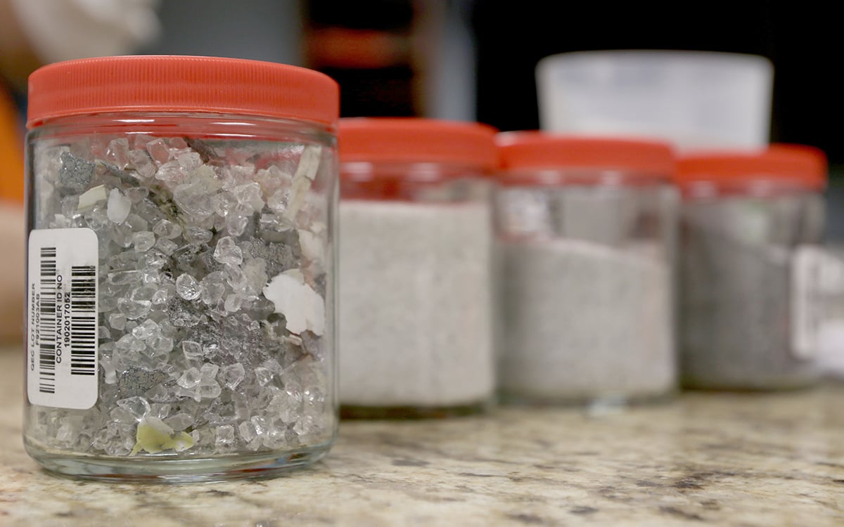A series of jars contain samples of recycled solar panel materials at We Recycle Solar in Yuma on Feb. 9, 2022. (Photo by Hope O’Brien/Cronkite News)