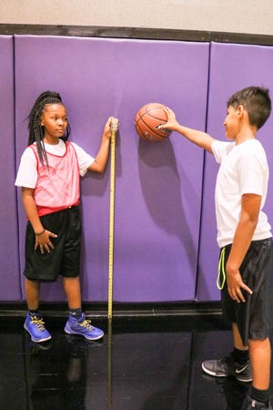 Boys and Girls Club members in the STEM Sports program collect data based on force and gravity in basketball from the Phoenix Suns practice court.