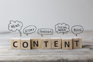 Wooden blocks spelling out content with speech bubbles that describe different types of content marketing such as news, social media, blogs, etc.